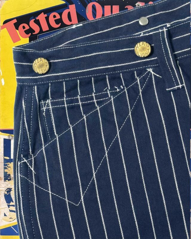 Lot No. HD42499
“HEADLIGHT 8oz. SPECIAL WOVEN STRIPE DENIM WAIST OVERALLS”
This season features woven stripe denim items, which were originally advertised in 1914 and are now almost non-existent in vintage collections. Rather than a print, the stripes are woven into the fabric, clearly positioning it as a competitor to Stifel’s Wabash stripes. An analysis was conducted using a fabric swatch attached to a novelty notebook distributed in retail stores. The fabric is made from No. 10 cotton thread in three colors—indigo, natural, and charcoal—woven in a left-hand twill.

Although this model has not been confirmed as part of Headlight’s line, it was based on Lot No.903 Pantaloon Overall, released by Crown Overalls, a company that later partnered with Headlight. The belt loops, introduced eight years earlier than the 501XX, are a notable feature. The silhouette is closer to overalls, with a wider cut, and the waist can be adjusted with a back strap. While the side seams are felled, hiding the selvedge, it can still be seen on the inside of the waistband pocket.
 
#SugarCaneDenim #ToyoEnterprise #HeadlightOveralls #WovenStripe #MadeinJapan